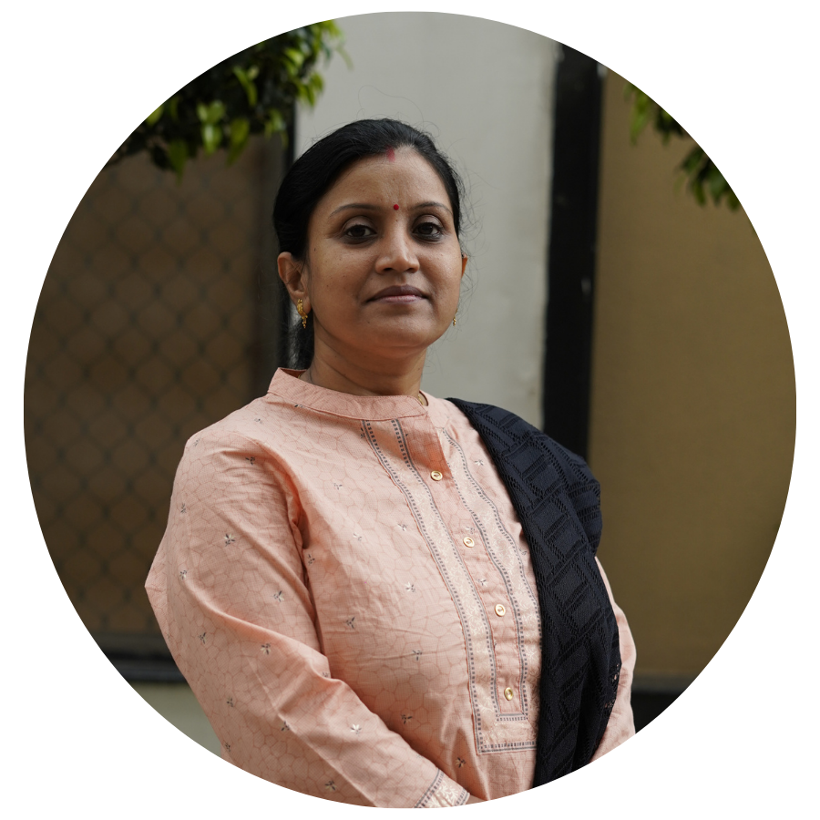 Woman with a bindi looking at the camera, slightly smiling. She is wearing a light pink kurta.